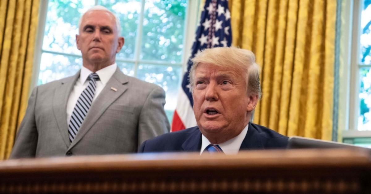 US President Donald Trump speaks to the press before signing a bill for border funding legislationin as Vice President Mike Pence looks on in the Oval Office at the White House in Washington, DC, on July 1, 2019. (AFP Photo)