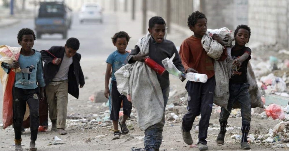 Children walk as they collect empty plastic bottles in a street, Sanaa, Nov. 21, 2019. (REUTERS Photo)