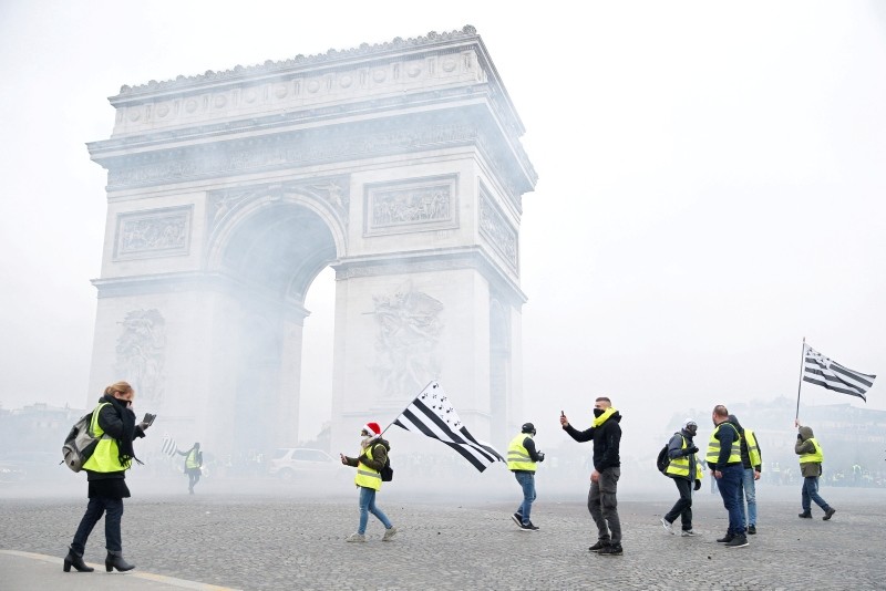 Tear gas floats in the air near the Arc de Triomphe as protesters wearing yellow vests, a symbol of a French drivers' gather to protest against higher diesel taxes, demonstrate in Paris, France, December 1, 2018. (REUTERS Photo)