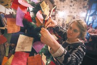A Syrian youth hangs New Year wishes written on a card on a Christmas tree in the Zeriab coffee shop in the Syrian capital Damascus.