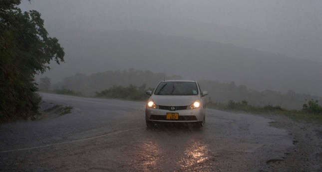 emThis picture taken on March 15, 2019 shows a vehicule as rain, which is believed to be the beginning of Tropical cyclone Idai coming from central Mozambique, falls in the flooded districts of Chikwawaa and Nsanje in southern Malawi (AFP Photo)/em