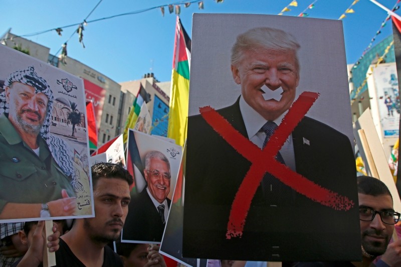 Palestinian protestors hold portraits of late Palestinian leader Yasser Arafat and US President Donald Trump during a rally in support to the Fatah movement in the West Bank city of Nablus. (AFP Photo)