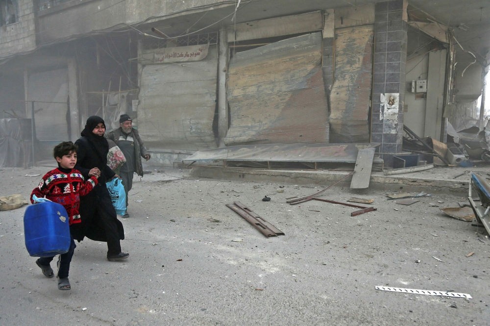Syrians run for cover in Hamouria during Syrian regime shelling on opposition-held areas in Eastern Ghouta on the outskirts of the capital Damascus, March 6.