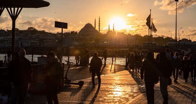 أشخاص يتجولون بمنطقة كاراكوي أثناء غروب الشمس في إسطنبول، تركيا، 9-11-2023. صورة: رويترز