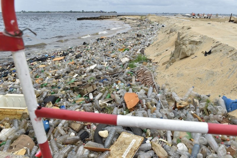 Plastic bottles and other waste lie on the sand after being washed ashore near the port of Abidjan on August 5, 2015 despite efforts by the government to promote a greener economy by banning plastic bags. (AFP Photo)