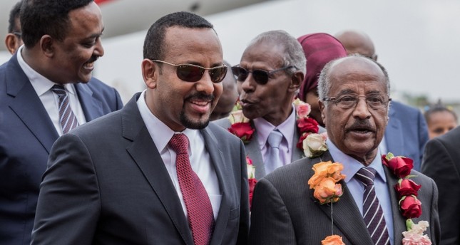 وزير الخارجية الإريتري عثمان صالح محمد إلى اليمين يسير مع رئيس وزراء إثيوبيا أبي أحمد الثاني من اليسار ووزير خارجية أثيوبيا يسارالفرنسية