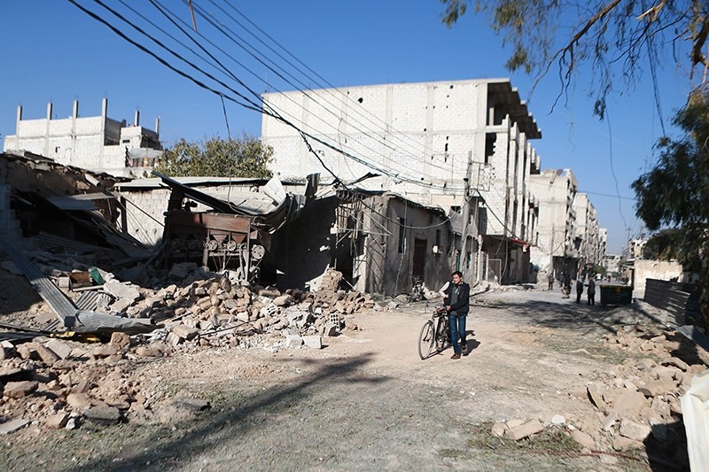 A Syrian man walks past a destroyed building following a reported air strike in the same area in the opposition-held besieged town of Arbin, in the Eastern Ghouta region, Dec. 2, 2017 (AFP Photo)