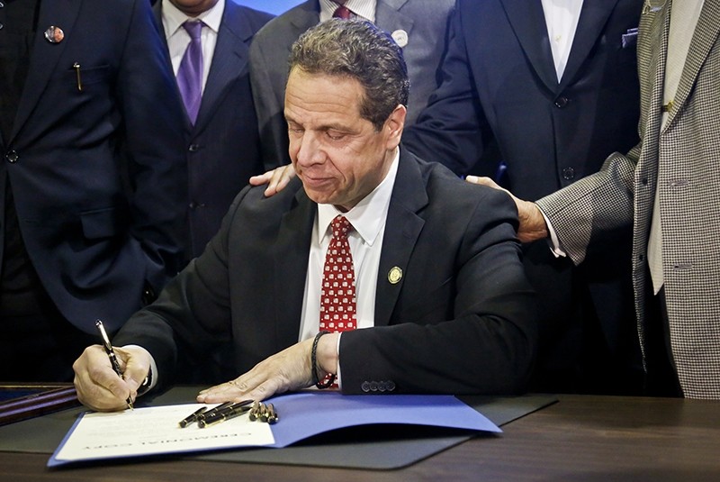 FILE - In this April 10, 2017, file photo, New York Gov. Andrew Cuomo signs new legislation for free state college tuition and juvenile justice reform, during a signing ceremony in New York (AP Photo)