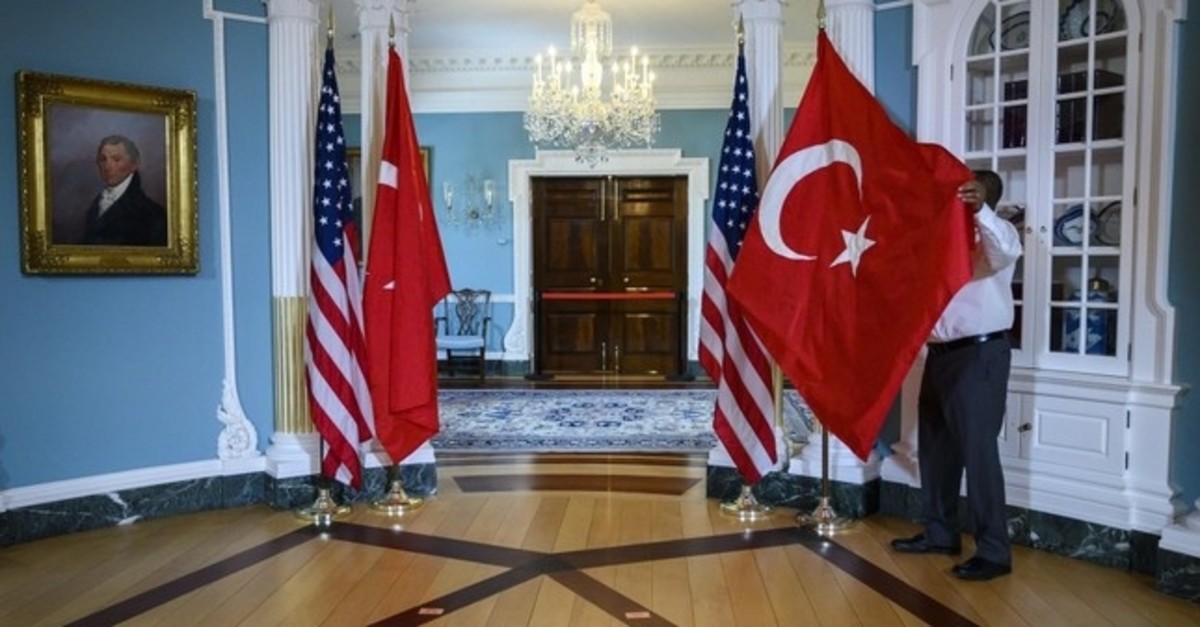 A U.S. State Department staffer adjusts a Turkish flag before a meeting between Foreign Minister Mevlu00fct u00c7avuu015fou011flu and U.S. Secretary of State Mike Pompeo at the State Department in Washington, D.C., April 3, 2019.