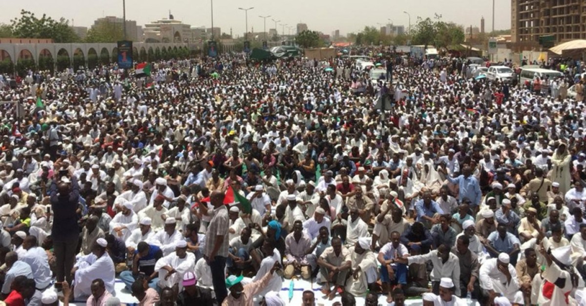 Sudanese protesters gather near the military headquarters in Khartoum as they continue to rally demanding a civilian body to lead the transition to democracy one day after a military council took control of the country, on April 12, 2019. (AFP Photo)