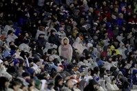 The crowd cover up from the rain as Storm Ciara hits during the Six Nations rugby union international match between Scotland and England at Murrayfield Stadium, in Edinburgh, Scotland, Feb. 8, 2020. (AP Photo)