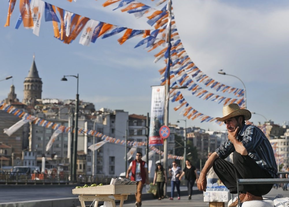 A street vendor in front of the iconic Galata Tower in Istanbul, where party flags and banners are displayed; the province expects to see a heated race for mayor in municipal elections in March next year.