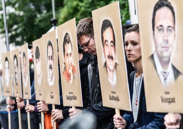 People hold banners with portraits  of migrants murdered by the racist NSU group, in front of the higher regional court in Munich, Germany, July 10. 
