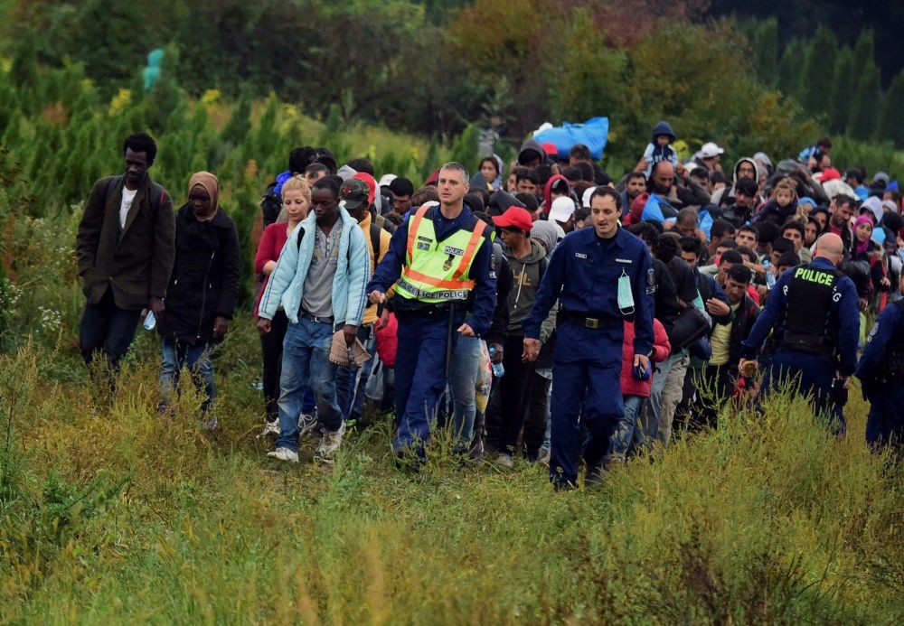 Police escort migrants after they crossed the border near the village of Zakany in Hungary to continue their trip to Gemany.