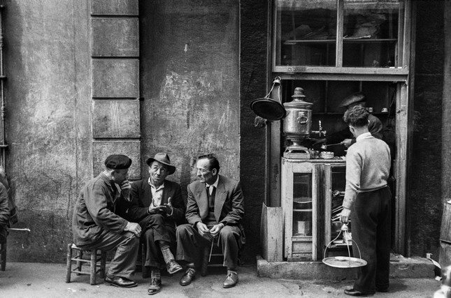Photo taken by legendary photographer Ara Güler shows three friends chatting in front of a tea house at Passage Hazzopulo in Beyoğlu, Istanbul, 1953.