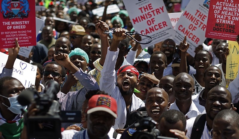 In this Wednesday, Feb. 15, 2017 file photo, a striking doctor holds his stethoscope in the air as he and other medical staff protest the detention of their union leaders, outside an appeal court in Nairobi, Kenya. (AP Photo)