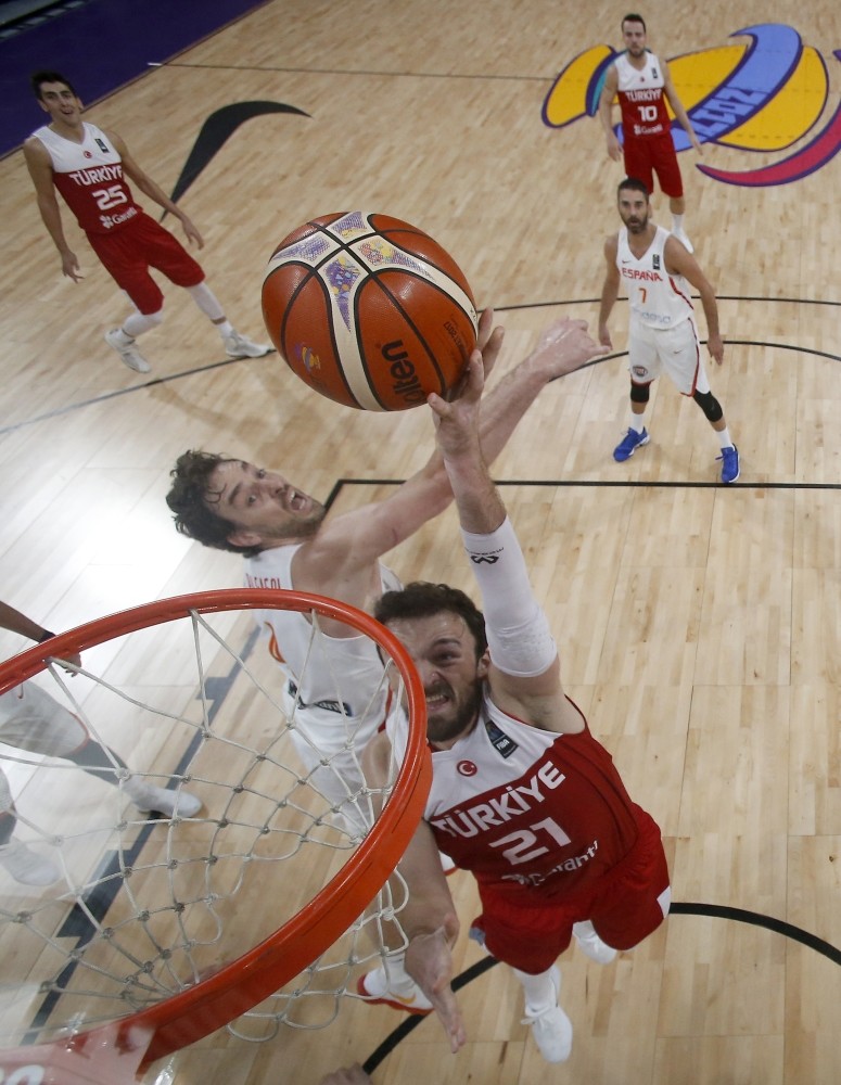 Sertau00e7 u015eanlu0131 jumps to score a basket as Spain's Pau Gasol tries to stop him during their Eurobasket round of 16 match in Istanbul.