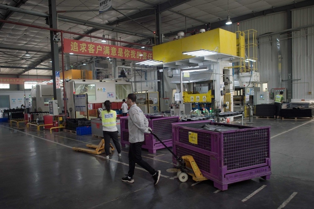 A worker pulls a trolley containing car interior pieces for a major European car maker in the American Industrial Park in Shenyang.