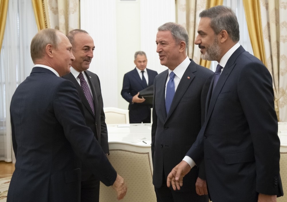 (From left to right) Russian President Vladimir Putin, Foreign Minister Mevlu00fct u00c7avuu015fou011flu, Defense Minister Hulusi Akar and intelligence chief Hakan Fidan talk to each other during their meeting in the Kremlin, Moscow, Aug. 24.