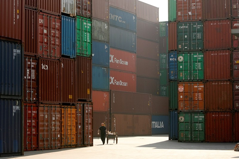 A woman walks past containers at a port in Shanghai, January 13, 2009. (Reuters Photo)