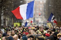 People hold up the French flag during a ,yellow vest, demonstration in the northern French city of Lille, Dec. 29. 