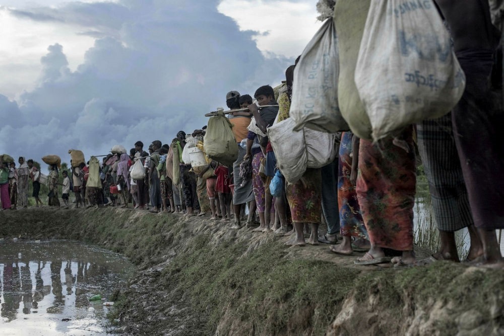 Rohingya refugees walk after crossing the Naf river from Myanmar into Bangladesh in Whaikhyang.