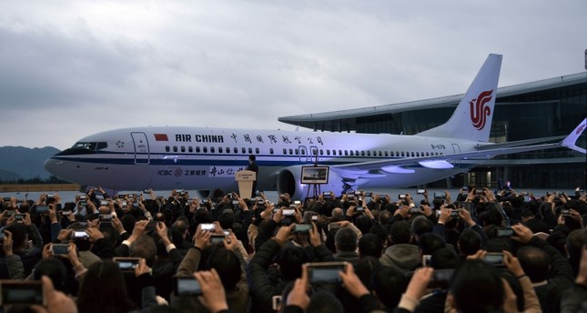 In this Dec. 15, 2018, photo, invited guests take photos of the Boeing 737 Max 8 airplane deliver to Air China during a ceremony at Boeing Zhoushan 737 Completion and Delivery Center in Zhoushan, east China's Zhejiang Province. (AP Photo)