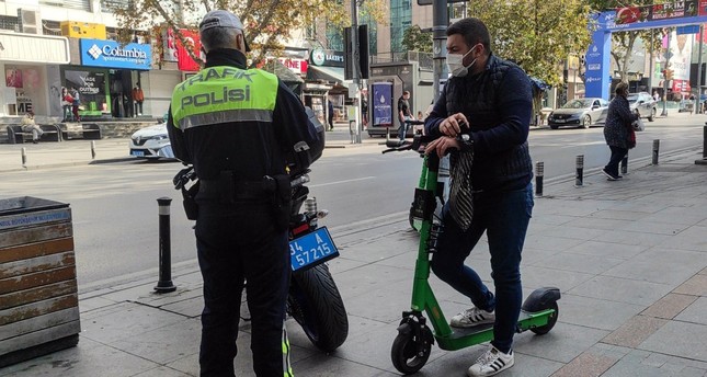 شرطي مرور يتحقق من أوراق راكب سكوتر في اسطنبول الأناضول