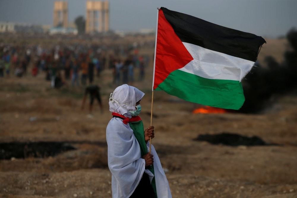 A woman holds a Palestinian flag during a protest calling for the lifting of the Israeli blockade on Gaza and demanding the right to return to their homeland, Oct. 19.