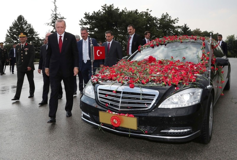 Erdoğan walks out of his car decorated with flowers thrown by supporters on his way the mausoleum of the nation's founding father Mustafa Kemal Atatürk, in Ankara.