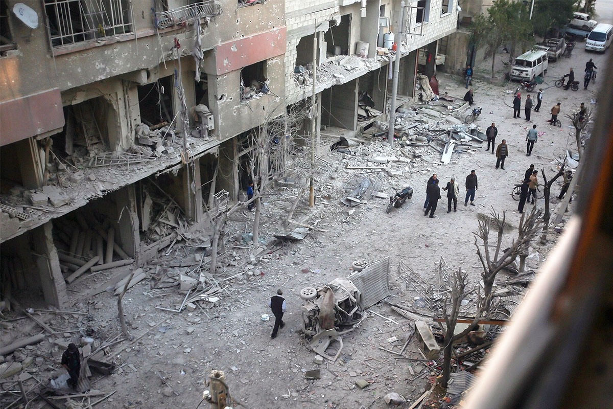 People inspecting damaged buildings after an airstrike by the Assad regime in opposition-held Douma, Syria, April 7. (EPA Photo)