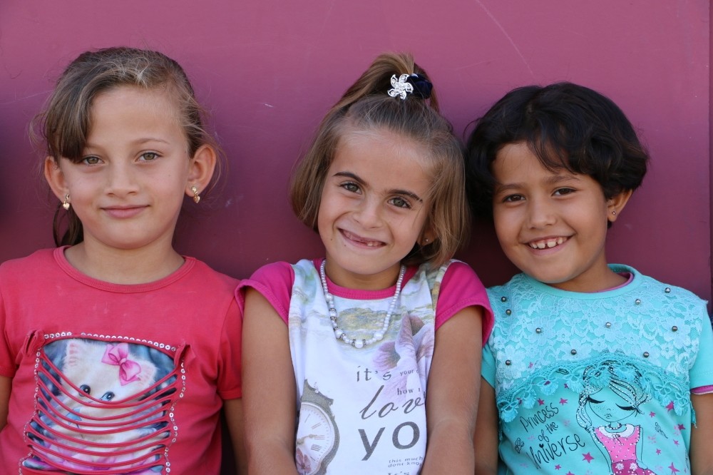 Syrian girls at the Harran Temporary Residential Center in u015eanlu0131urfa, Turkey are photographed with a smile.