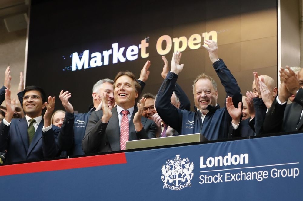 Andy Palmer (C-R), CEO of Luxury British sports car manufacturer Aston Martin applauds in celebration as the company was floated on the London Stock Exchange on Oct. 3.