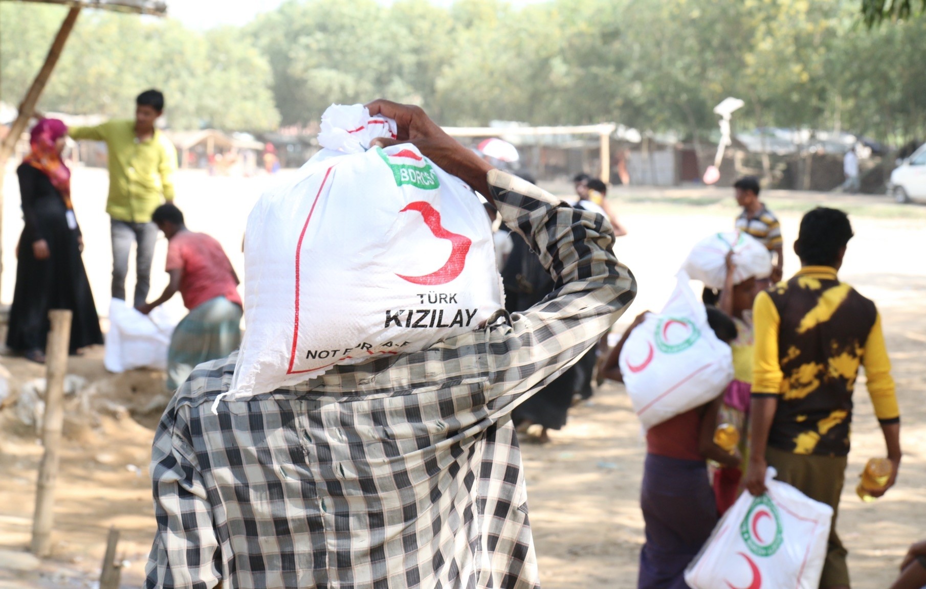 A man carries a bag with food aid distributed by the Turkish Red Crescent at a camp for Rohingya Muslims in Bangladesh in this undated photo.