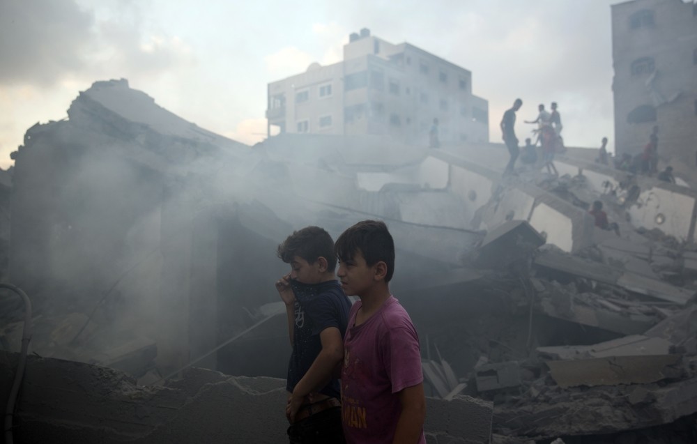 Palestinians inspect the damaged building of Said al-Mis'hal cultural center after it was hit by an Israeli airstrike, Gaza City, Aug. 9.