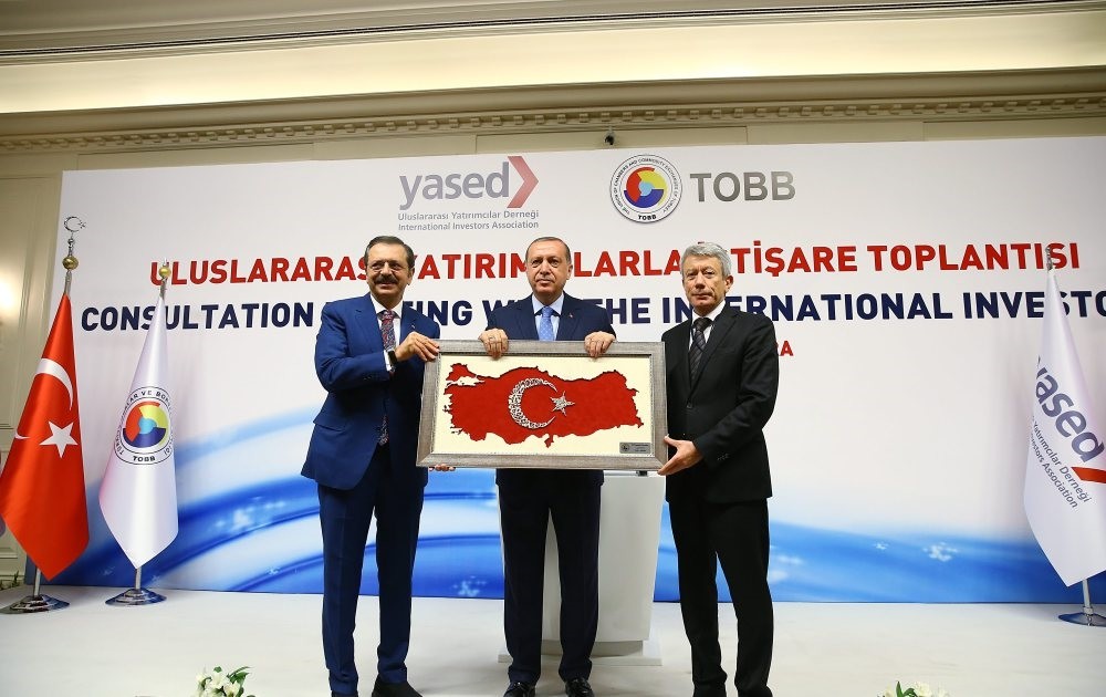 President Erdou011fan (C) met foreign investors at the Consultation Meeting with the International Investors and was presented with a gift by Chairman of TOBB Rifat Hisarcu0131klu0131ou011flu (L) and YASED Chairman Ahmet Erdem (R).