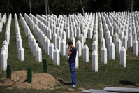 A man prays among gravestones at the memorial center of Potocari near Srebrenica, Bosnia-Herzegovina, Aug. 14, 2018.