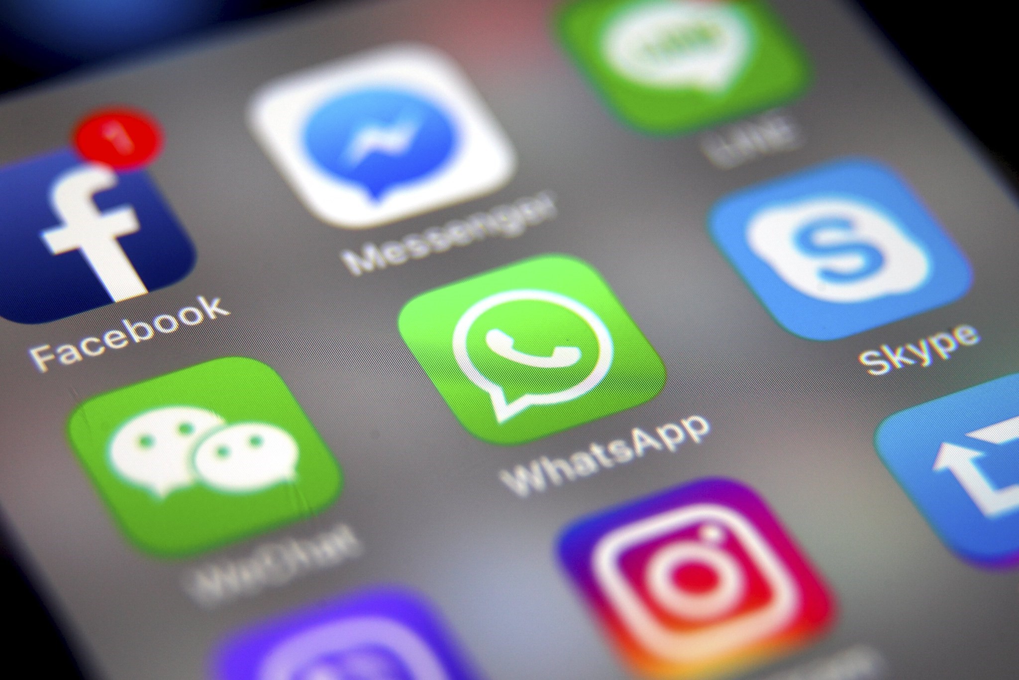 The logo of the messaging application WhatsApp (C) is pictured on a smartphone screen with the Facebook (top L) app logo in Taipei, 26 September 26 2017. (EPA Photo)