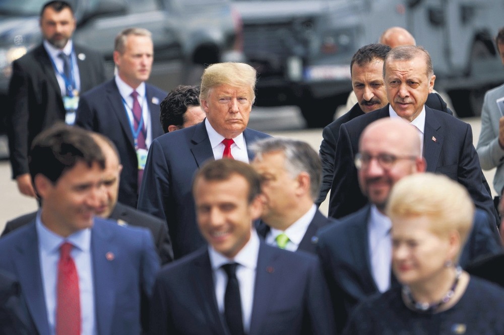 U.S. President Trump (L) and President Erdou011fan (R), with other leaders (front), go to take a family photo during the NATO Summit in Brussels, July 11. 