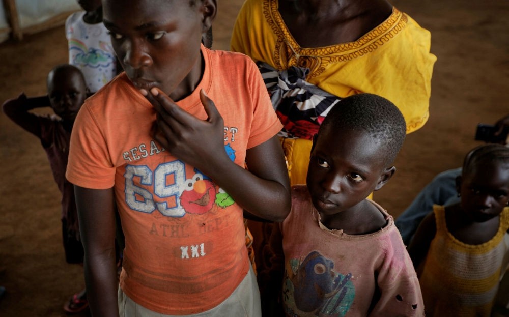 Unaccompanied South Sudanese refugee children line up to have their details recorded before being taken to a refugee transit center, in Kuluba, northern Uganda.