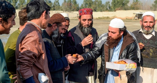 أفغاني يوزع الحلوى احتفاءً بالهدنة AP