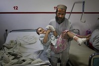 In this Thursday, Dec. 12, 2019, photo, Ismatullah carries his 9-year-old son Eimal, who has lost his right eye and several fingers on his hands in a landmine blast, at Emergency Surgical Center for Civilian War Victims in Kabul, Afghanistan. (AP Photo)