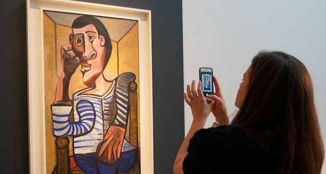 In this file photo taken on May 3, 2018 a Christie's employee takes a picture of Pablo Picasso's Le Marin during a media preview at Christie's in New York. (AFP Photo)
