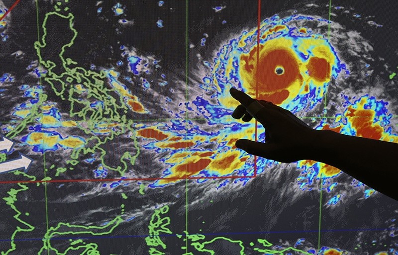 Filipino forecaster Meno Mendoza illustrates the path of Typhoon Mangkhut as it approaches the Philippines, at the Philippine Atmospheric, Geophysical and Astronomical Services Administration in Manila, Philippines on Sept. 12, 2018. (AP Photo)
