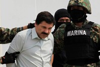 Joaquin ,El Chapo, Guzman (L) is escorted by soldiers during a presentation at the Navy's airstrip in Mexico City Feb. 22, 2014. (Reuters Photo)