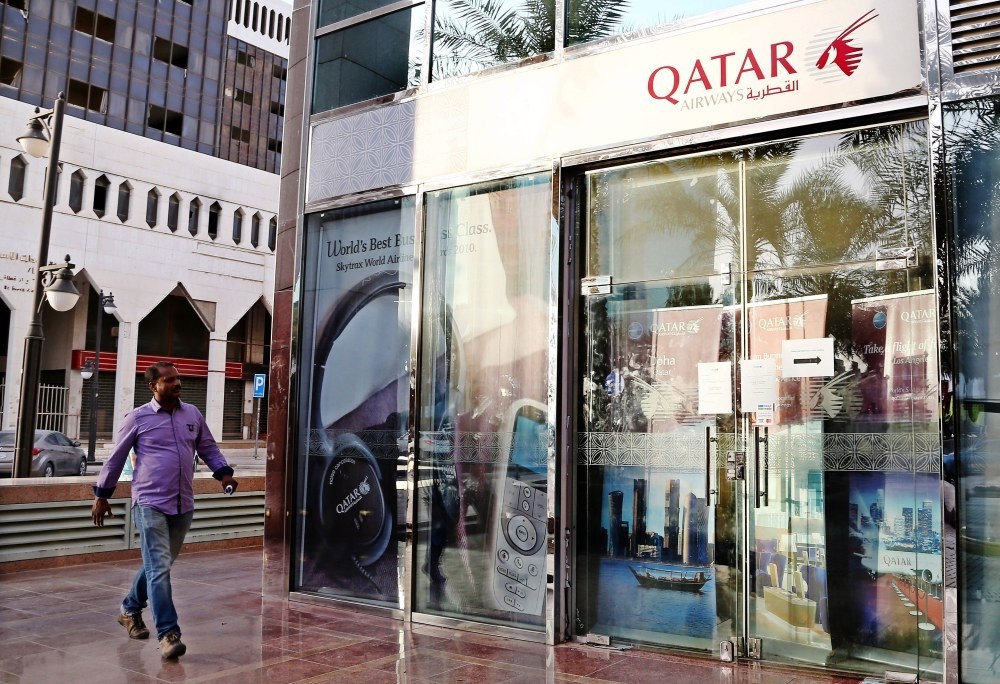 A man passes the closed office of Qatar Airways in King Fahad Road, Riyadh, Saudi Arabia, June 6. -