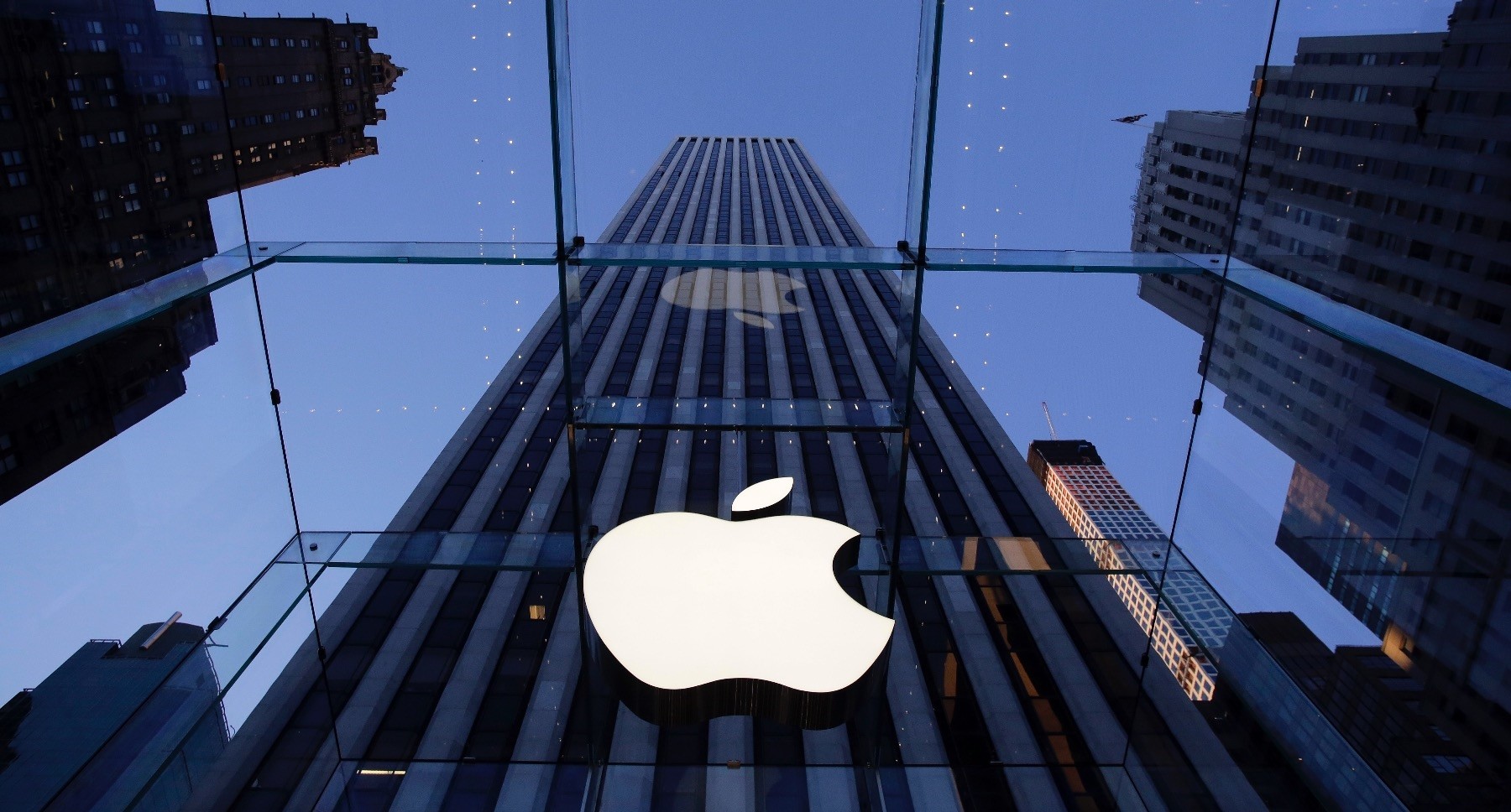 The Apple corporate logo hangs in the iconic glass box entrance to the company's Fifth Avenue store, New York, Sept. 5, 2014.