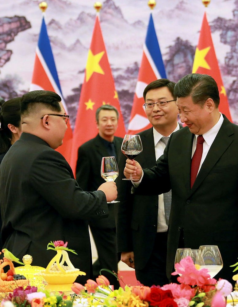 This picture from North Korea's official Korean Central News Agency (KCNA) taken on March 26, 2018 and released on March 28, 2018 shows China's President Xi Jinping (R) and North Korean leader Kim Jong Un (L) raising their glasses at the Great Hall of the People in Beijing.