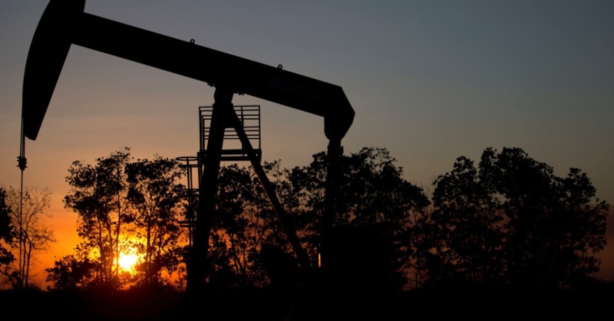 In this Feb. 19, 2015 photo, the sun sets behind an oil well in a field near El Tigre, Venezuela. (AP Photo)