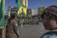 Terrorists from the Women's Protection Units (YPJ), the women's branch of the YPG, that recruits children, celebrate their so-called victory holding a flag bearing the photo of PKK leader Abdullah u00d6calan in Raqqa, Syria in October 2017.